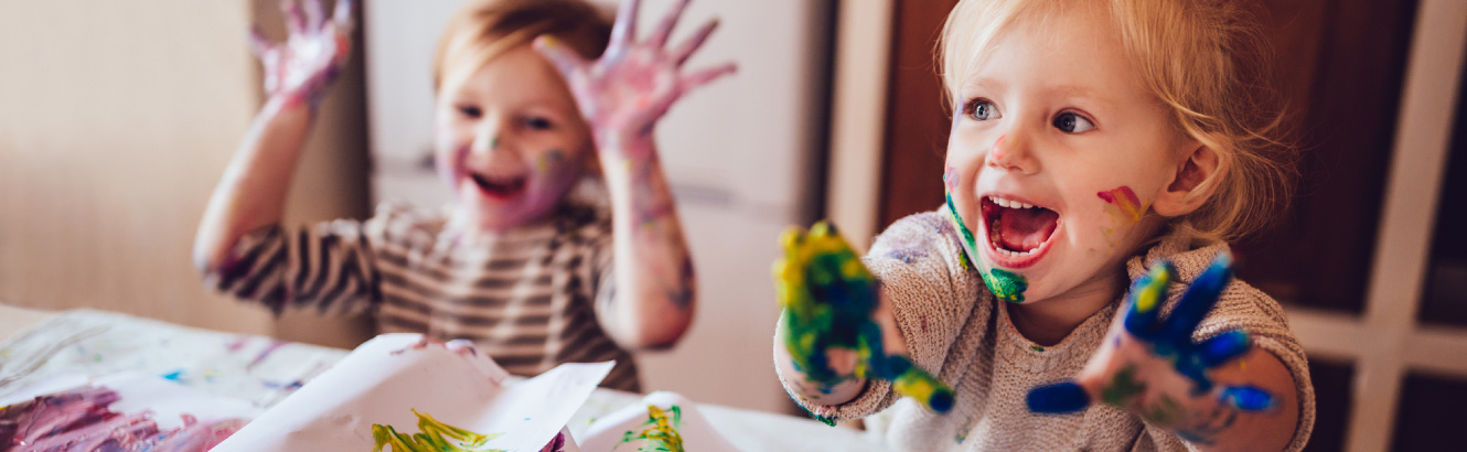 Kids playing with finger paint.